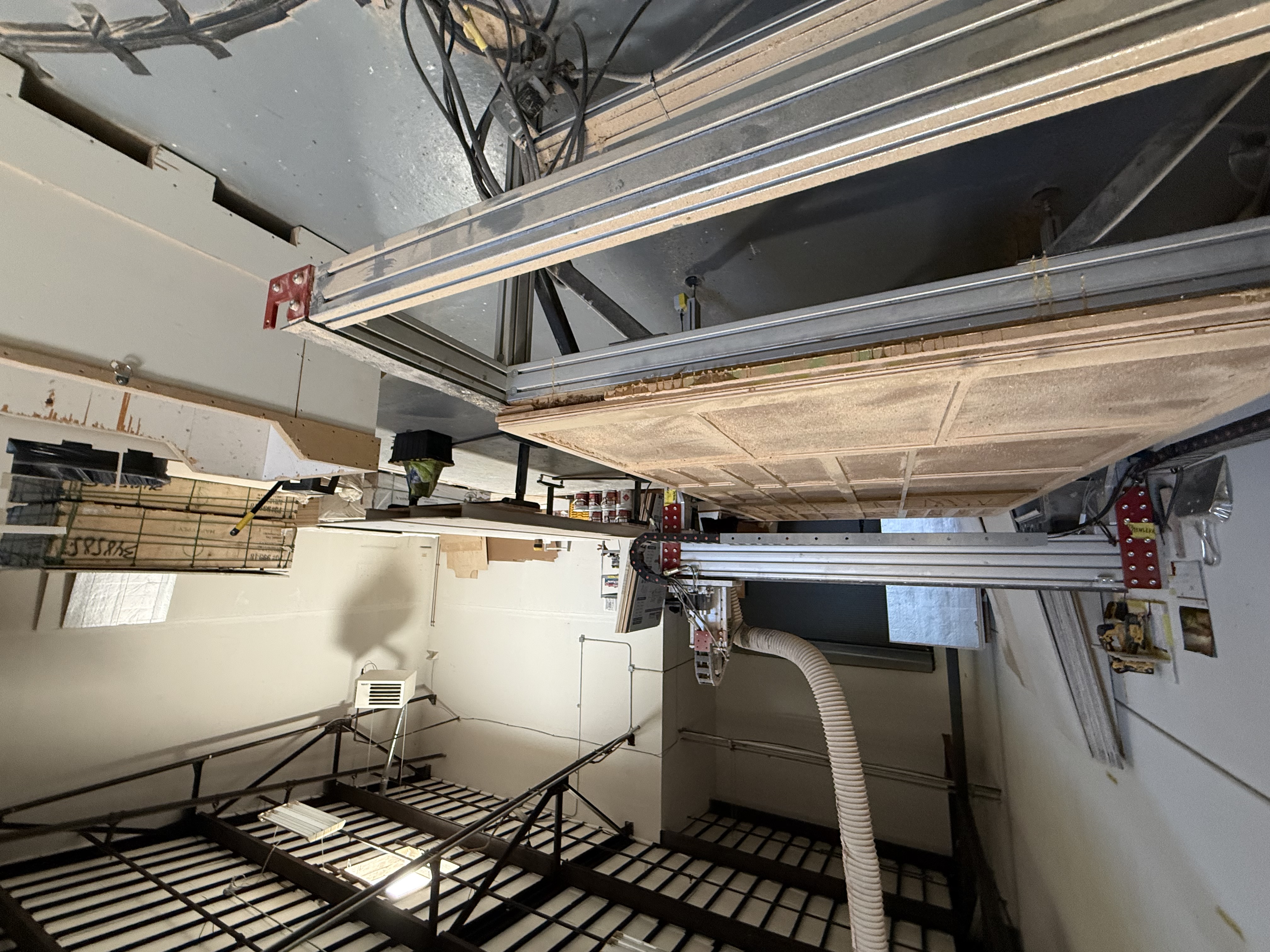 CNC cutting area with a large CNC router and overhead rails.