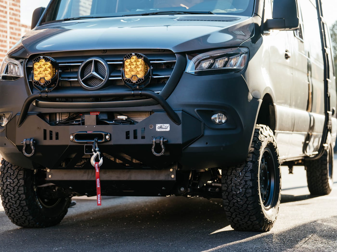 Finished adventure van parked near a canyon with exterior gear installed.